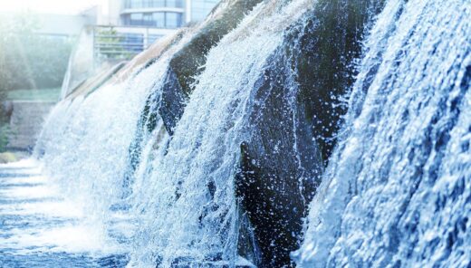 Kaltes, klares Wasser eines dekorativen künstlichen Wasserfalls