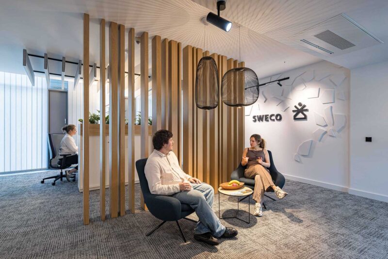 Sweco Köln Bürokonzept – Offener Workspace mit Mesh-Stühlen vor Holzlamellenwand